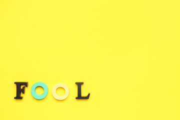 Word FOOL on yellow background
