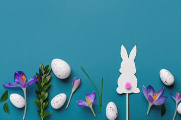 Composition with Easter eggs, paper bunny, beautiful crocus flowers and plant leaves on blue...