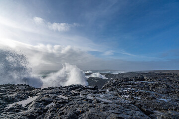 Black rocks on the coast of Iceland with big waves