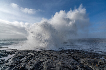 Black rocks on the coast of Iceland with big waves