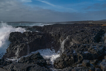 Fototapeta premium Black rocks on the coast of Iceland with big waves