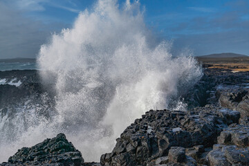 Fototapeta na wymiar Black rocks on the coast of Iceland with big waves