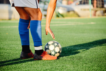 Soccer player putting ball on the soccer field. Legs of a soccer player. Preparing the soccer free kick. © Julieta