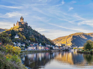 Fototapeta na wymiar Riverside shot of Cochem town and castle in the afternoon during colourful autumn season in Cochem-Zell district, Germany
