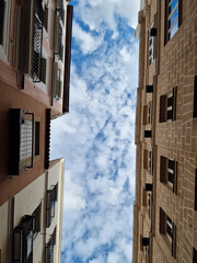 An interesting perspective of a fragment of the blue sky between the tenements of the Old Town in Madrid on a sunny winter day, Madrid, Spain.