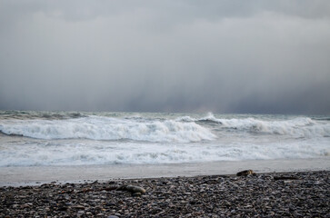 Storm on the sea, waves and gray rain clouds