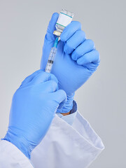 Vaccine vial, needle and doctor hands in studio for safety, healthcare and pharmaceutical medicine. Closeup person, vaccination and injection bottle for virus, immunity and medical antibiotics drugs