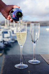 Everyday party, pouring of cava or champagne sparkling wine in glasses in yacht harbour of Caleta Fuste, Fuerteventura, Canary islands vacation, Spain