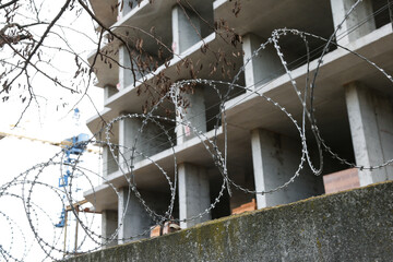 barbed wire on the fence on the wall close-up