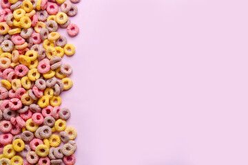 Heap of colorful cereal rings on lilac background