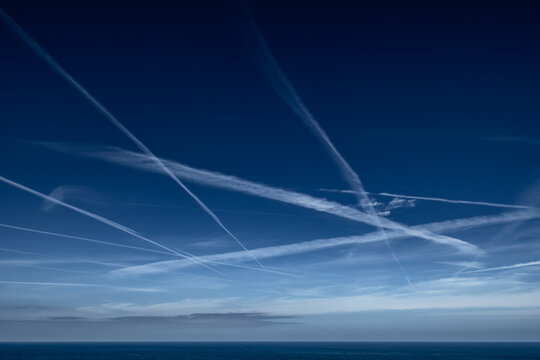 Blue Sky With Grid Of White Condensation Trails, Contrails, From Airplane At The Atlantic Coast In France - Powered by Adobe