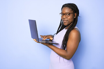 Attractive young African American woman using her high-tech electronic device to help her in education isolated on light purple background
