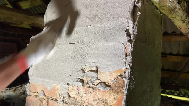 Plastering a stove pipe in a rustic house.