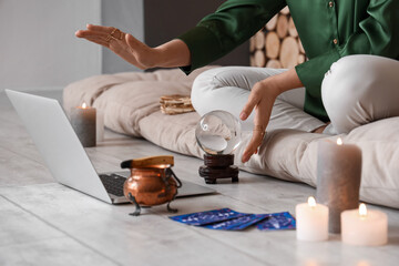 Young clairvoyant with crystal ball recording video for blog at home
