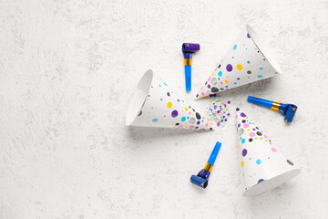 Composition with party hats, whistles and confetti on light background