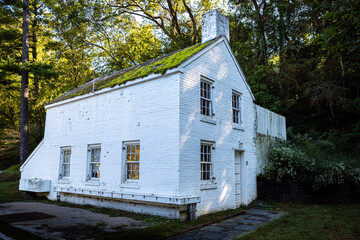 Old white house on the Great Falls Overlook Trail by the Potomac River in Maryland, USA.