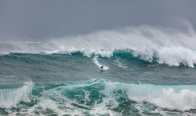 Surfing big waves in the ocean in Australia