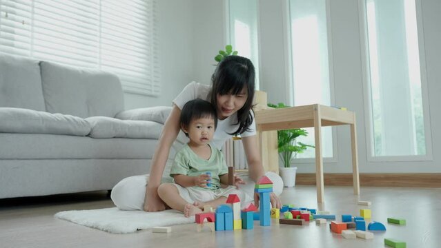 Happy Asia mother play and learn toy blocks with the little girl. Funny family is happy and excited in the house. Mother and daughter having fun spending time together. Holiday, Activity, development