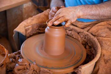 Close up of hands working on pottery wheel in workshop
