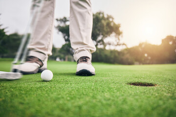 Golf, hole and legs of athlete or player hit ball and professional golfer training and putting on a filed as exercise or workout. Feet, equipment and gentleman or person relax and playing a sport