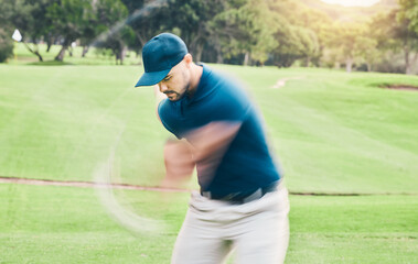 Obraz premium Golf, motion blur and hobby with a sports man swinging a club on a field or course for recreation and fun. Golfing, grass and training with a male golfer playing a game on a green during summer