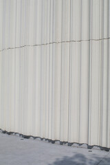 Abstract white Wave  cement curve wall background with sunlight and shadow of leave. Outdoor Structures. Minimal Futuristic 