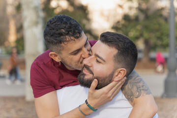 gay couple in the park, cuddling, loving and playful