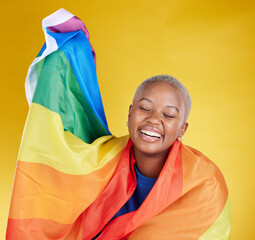 Laughing, lgbtq and black woman with pride flag in studio isolated on a yellow background. Gay, homosexual and lesbian, queer or funny, happy or comic African female with banner for trans or bisexual - obrazy, fototapety, plakaty