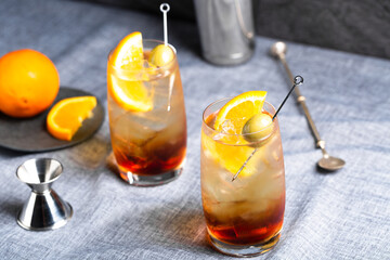 Refreshing vermouth and soda cocktail with orange slice and an olive as garnish