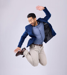Businessman, excited and jumping in studio with happy smile with winning expression on white...