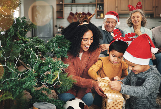 Love, Christmas and family opening presents, festive and happiness with quality time, joy and bonding. Grandparents, mother and children with gifts, Xmas and loving together with smile or celebration