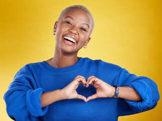 Heart hands, portrait and happy black woman in studio, background and color backdrop for emoji. Smile, female model and finger shape for love, thank you and support of peace, care or sign of kindness