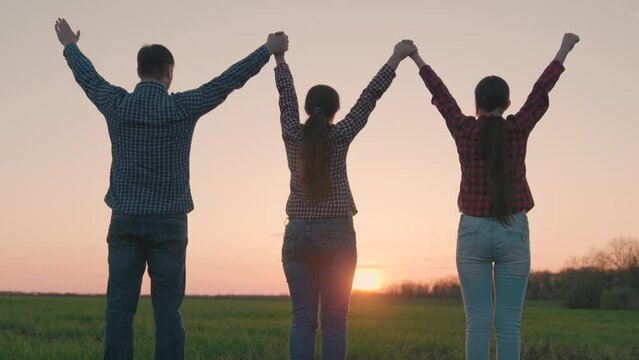 Happy family team holding hands raise their hands. Teamwork of people. Group of people of different ages, sunset. Partnership, help business concept. Family business. People pray together, nature, sun