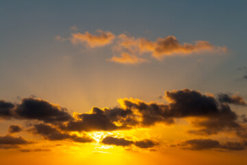 Incredible sunset with vibrant colors and clouds covering the sun. Free space to write.