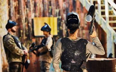 Paintball, back view or woman with gun in game or competition for fitness, exercise or cardio...