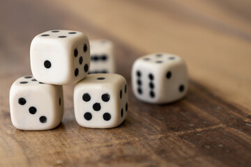 Closeup to five dice on a wooden table. Selective focus.