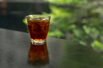 A glass of dark liquid with ice cubes in it