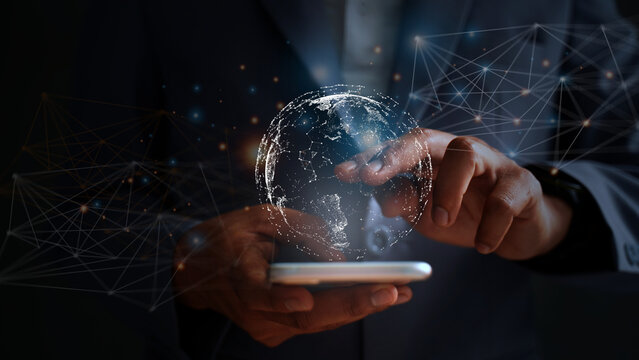 Young businessman in suit using smartphone, global big data connection concept through virtual technology analyzing economic market data to cover regions