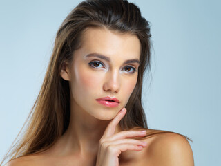 Fototapeta premium Face, serious and portrait of woman with beauty on blue background for wellness, skincare and spa treatment. Salon aesthetic, dermatology and face of confident girl with cosmetics, makeup and facial
