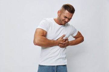 Man heart pain, heart attack and stroke, in white T-shirt on white isolated background, copy space