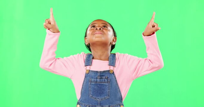 Children, pointing and a black girl on a green screen background in studio for marketing a product. Kids, portrait and advertising with a cute little female child showing space on chromakey mockup