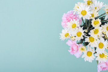 Ramo de flores de margaritas blancas y claveles rosa sobre fondo de color azul ideal para banners de ofertas, avisos de primavera