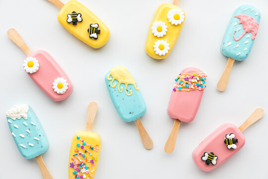Top down view of several homemade cakesicles decorated for Spring and Easter.