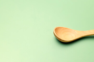 Wooden spoon on green background