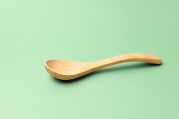 Wooden spoon on green background