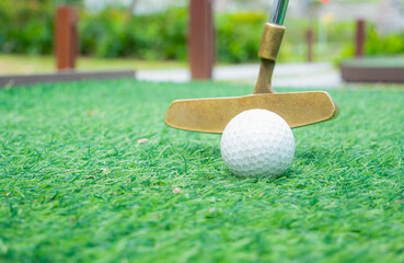Simulated golf putting area or practice area. Popular outdoor sport. Use putter sticks to prepare golf putts into holes. on the artificial green grass
