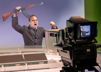 An emotional man raises a gun in a television studio