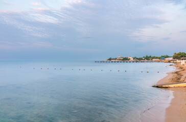 Tranquil Beach Sunrise. Closeup sea sand beach. Beautiful panoramic landscape, colorful golden sunrise over calm sea with waves