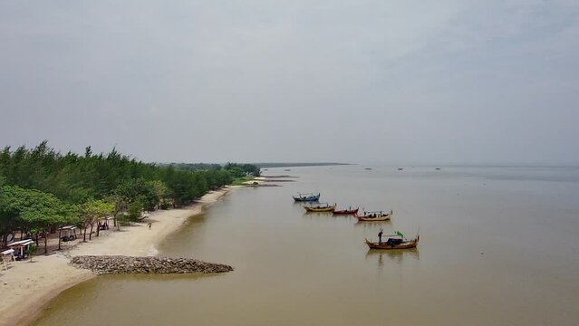 beautiful views of the white sand beach with several fishing boats leaning close to it