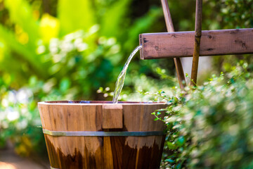 water flowing into a glass, Wooden barrels for natural onsen, steam hot water from natural hot springs, soft focus.